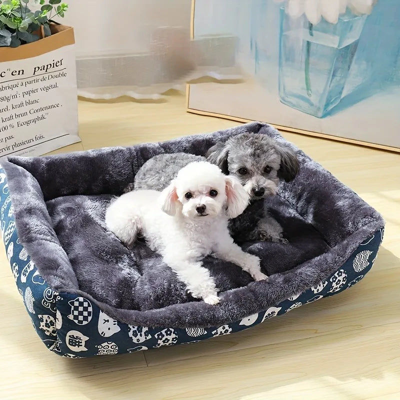 Two small dogs cuddling in a navy blue plush dog calming bed with owl pattern